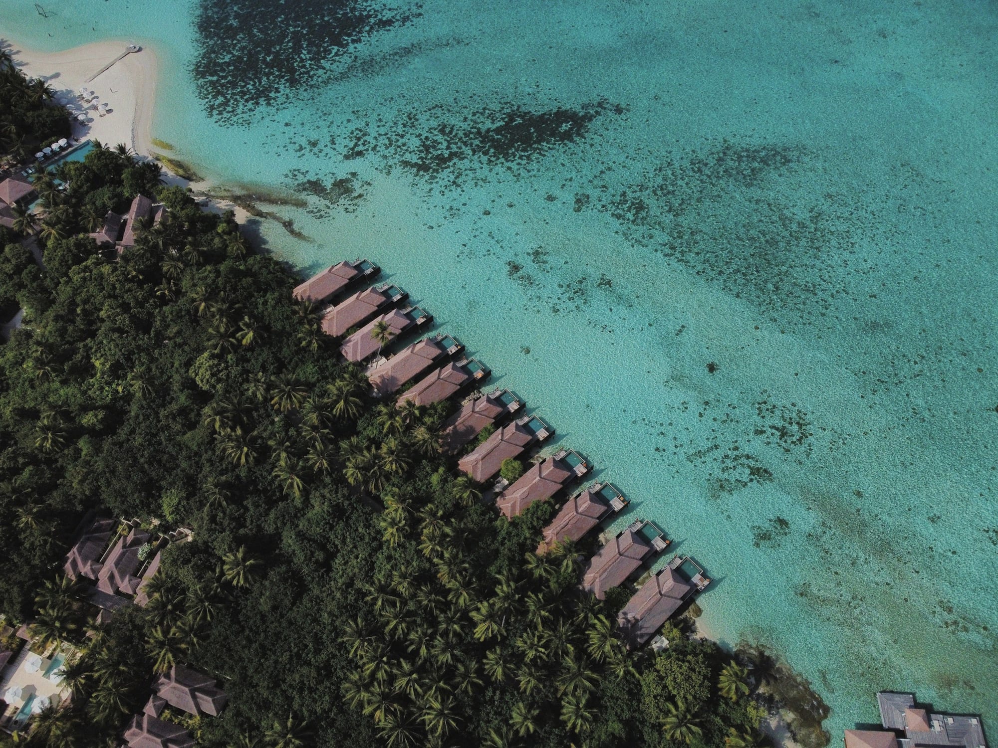 An aerial view of an overwater resort on a Maldivian atoll.