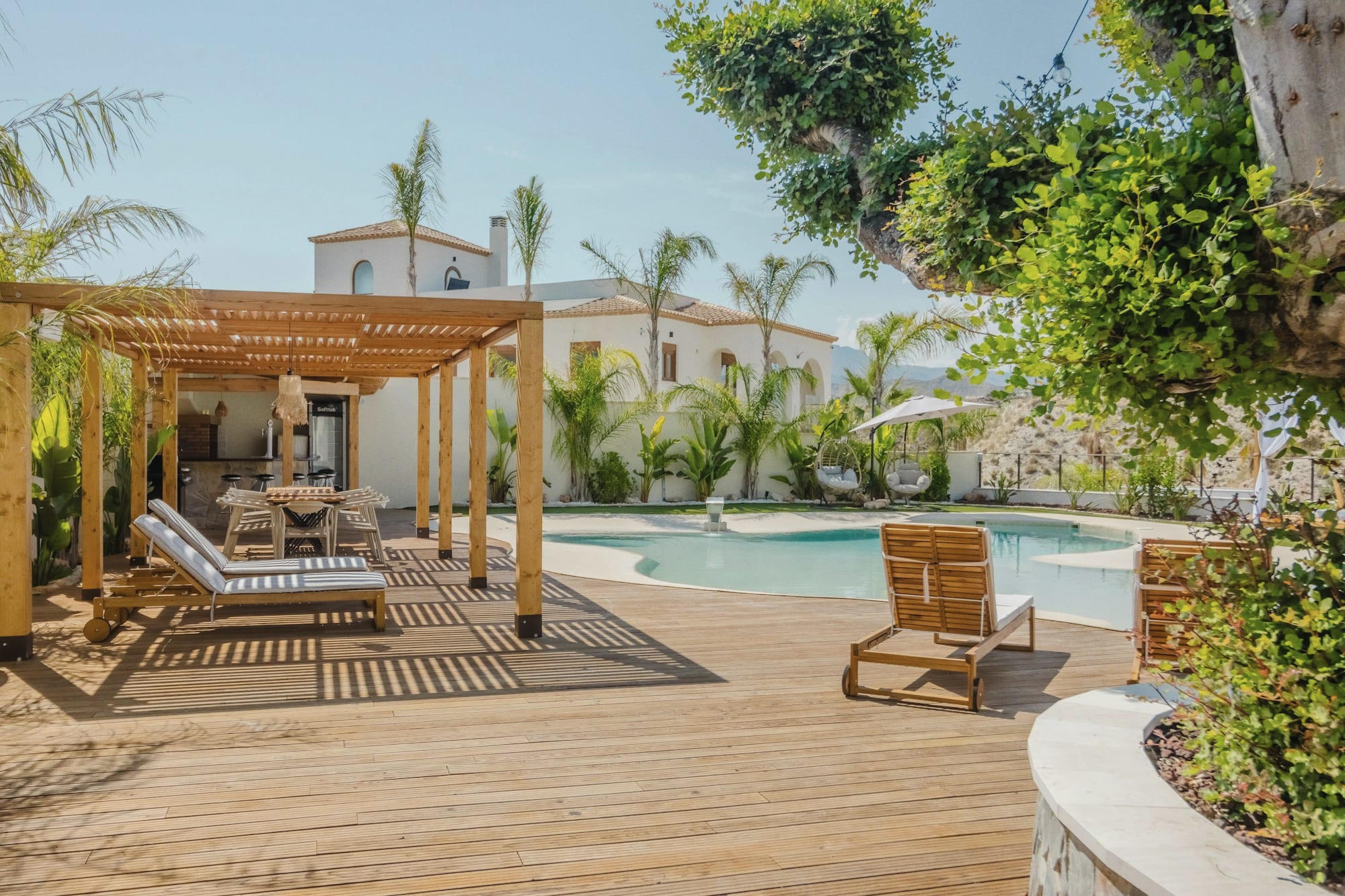 A villa terrace above a pool, laid for a long lunch.
